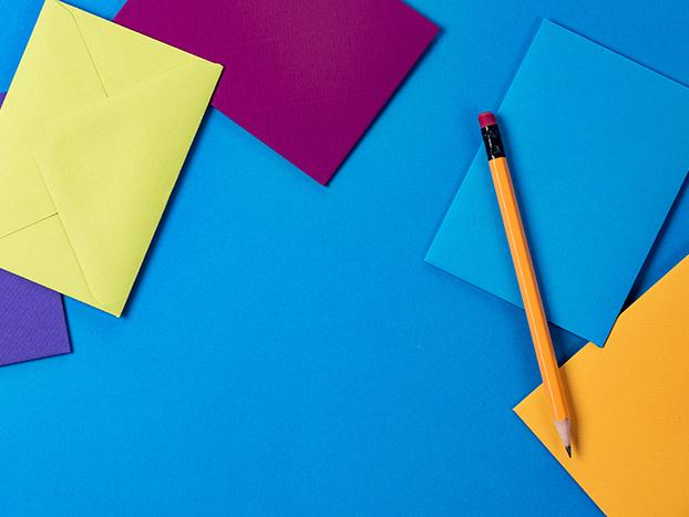 Colourful envelopes and a pencil, standing in for email campaigns